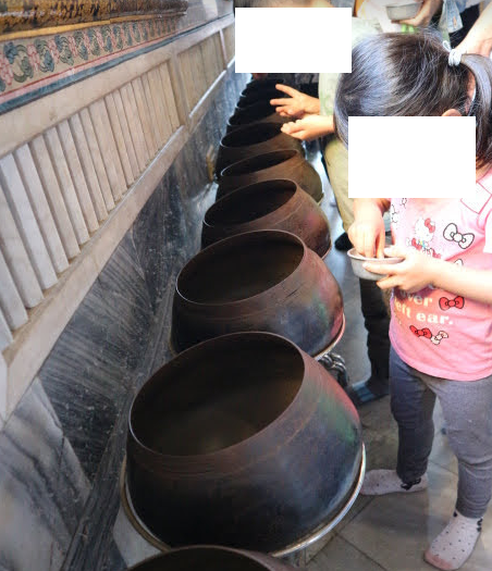 Coins pot at Reclining Buddha Bangkok Thailand.