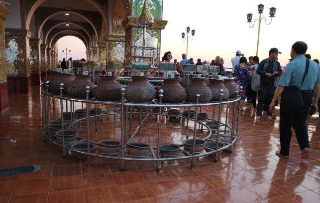 The pots filled with coins at Mandalay hill temple.